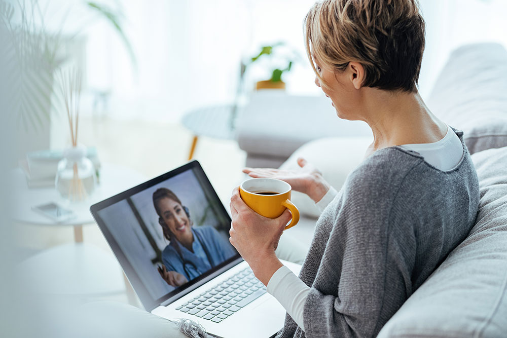 woman-using-laptop-having-video-call-with-her-doctor-while-sitting-home